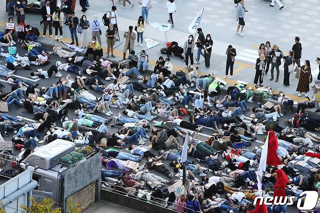 기후정의행진 참가자들이 지난해 9월24일 서울시청 인근 세종대로에서 화석 연료와 생명 파괴 체제 종식을 촉구하며 행진하던 중 기후위기를 경고하며 드러눕는 다이-인(Die-in) 시위를 하고 있다. ⓒ News1 조태형 기자