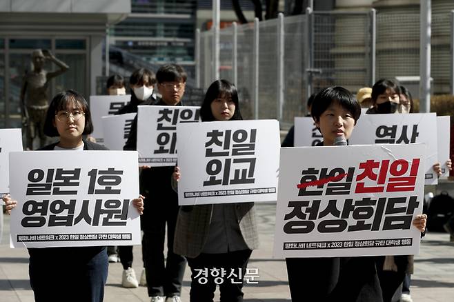 평화나비 네트워크 회원들이 지난 16일 서울 용산역 광장 강제징용노동자 상 앞에서 열린 ‘반성없는 한일정상회담 규탄, 굴욕적 강제동원 해법안 거부 대학생 공동행진’에 참석해 손펫말을 들고 서 있다. 문재원 기자