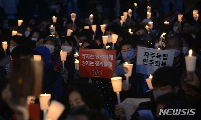 [전주=뉴시스] 김얼 기자 = 20일 전북 전주시 풍남문광장에서 '윤석열 퇴진 촉구 시국미사'가 열린 가운데 시국미사에 참여한 시민들이 촛불을 흔들고 있다. 2023.03.20 pmkeul@nwsis.com