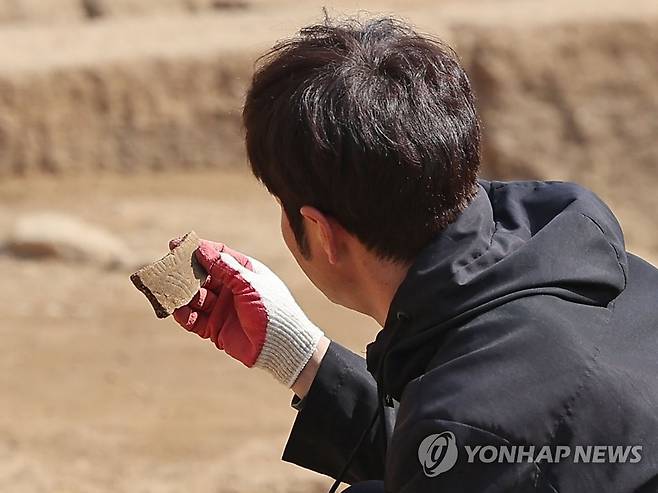 이것이 고려시대 유물? (서울=연합뉴스) 류영석 기자 = 20일 서울 종로구 신영동에 있는 한 도시형 생활주택 신축 부지에 현장 관계자가 출토된 고려시대 추정 유물을 살피고 있다. 2023.3.20 ondol@yna.co.kr