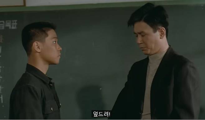 지난 1992년 상영된 영화 '우리들의 일그러진 영웅'에서 담임 김 선생(최민식 분)이 엄석대(홍경인 분)의 횡포를 벌주기 위해 '엎드려'를 시키는 장면./뉴스1