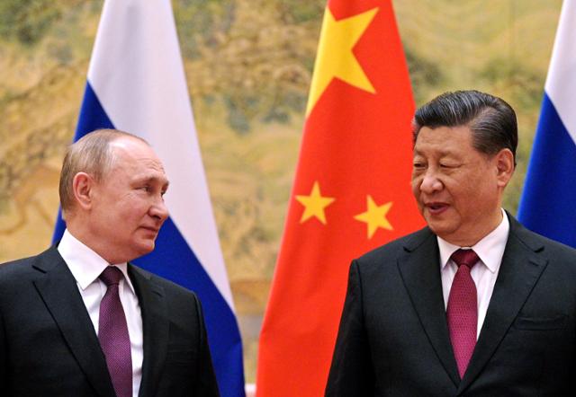 지난해 2월 4일 중국 베이징에서 열린 회담 중 시진핑(오른쪽) 국가주석이 블라디미르 푸틴 러시아 대통령과 대화를 나누고 있다. 베이징=AP 뉴시스
