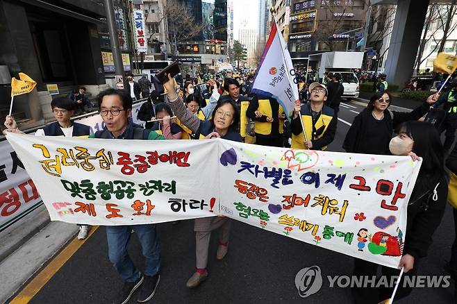 권리중심 중증장애인 맞춤형 공공일자리 제도화하라 (서울=연합뉴스) 황광모 기자 = 21일 오후 서울 중구 서울시청 인근 도로에서 열린 지속 가능한 권리중심 중증장애인 맞춤형 공공일자리를 위한 결의대회를 마친 참가자들이 행진하고 있다. 2023.3.21 hkmpooh@yna.co.kr