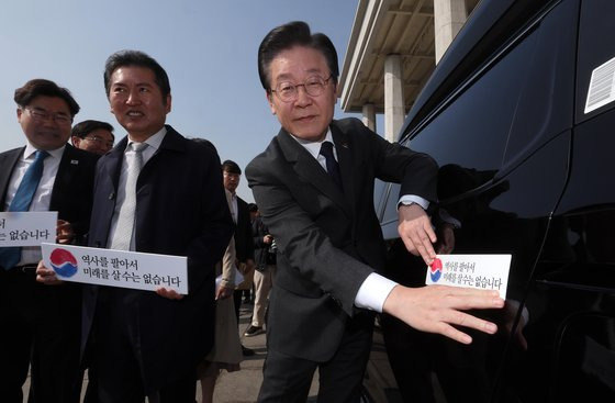 이재명 더불어민주당 대표가 22일 국회 본청 앞에서 열린 대일굴종외교 규탄 태극기달기 운동 행사에서 '역사를 팔아서 미래를 살 수는 없습니다' 문구가 담긴 태극기 스티커를 차량에 붙이고 있다. 김성룡 기자