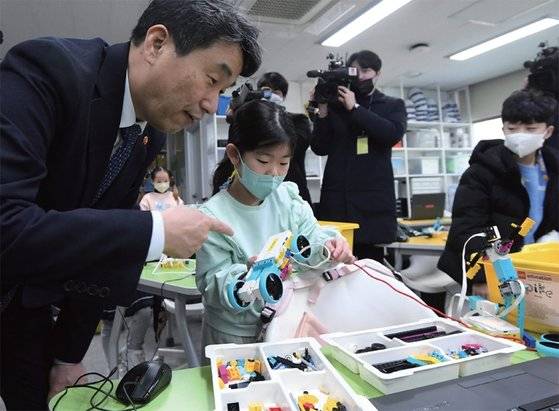 ‘늘봄학교’ 관련 현장을 방문해 한 학생이 만든 자동차 코딩로봇에 대해 설명을 듣고 있는 이주호 교육부 장관. 늘봄학교는 학부모의 방과 후 양육 부담을 덜고 국가의 책임을 강화하는 것을 골자로 한다. / 사진:연합뉴스