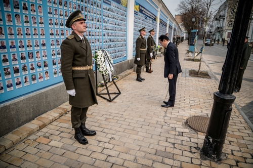 기시다 후미오 일본 총리가 21일(현지시간) 우크라이나 수도 키이우를 방문해 전사자 추모의 벽에 헌화하고 있다. 로이터연합뉴스