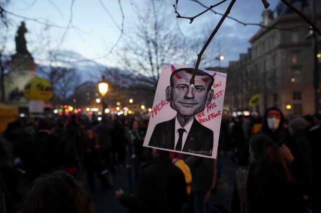프랑스 정부의 연금개혁 강행 반대 시위에 나선 시민들이 22일(현지시간) 파리에서 ‘우리는 당신의 바보가 아니다’라는 문구가 적힌 에마뉘엘 마크롱 대통령 사진을 들고 시위하고 있다. AP연합뉴스