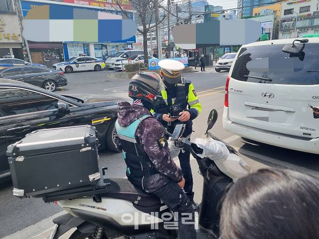 23일 이륜차 교통법규 위반 등 합동단속 도중 배달노동자가 신호위반으로 적발돼 정차하고 있다.(사진=조민정 기자)