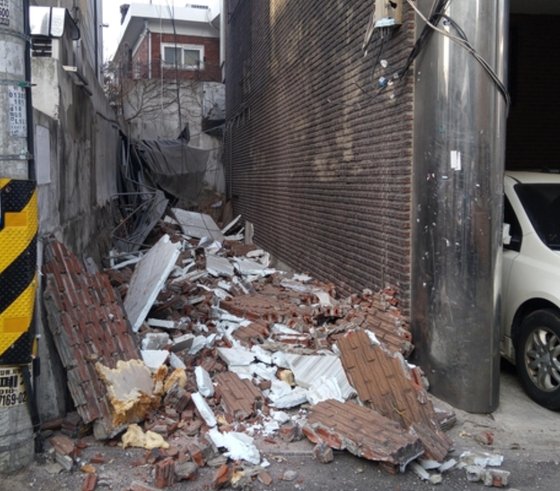 23일 오후 서울 강북구 수유동 한 4층 빌라 건물 외벽 일부가 무너져 내린 모습. 잔해가 바닥에 깔려있다. 연합뉴스