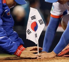 2009 월드 베이스볼 클래식(WBC) 2라운드에서 일본을 꺾고 우리나라의 4강을 확정 지은 직후 봉중근(사진 왼쪽)과 이진영이 미국 샌디에이고 펫코 파크 마운드에 태극기를 꽂고 있다. 사진=연합뉴스.