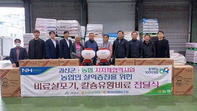 충북 괴산농협이 23일 지자체협력사업으로 마련한 비료살포기와 칼슘유황비료를 농민에게 전달하고 있다.