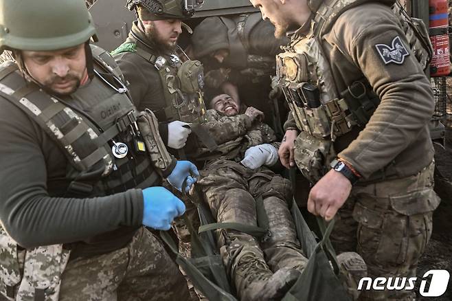 23일(현지시간) 우크라이나 바흐무트 전선에서 병사들이 러시아 군과 전투 중 부상병을 옮기고 있다. ⓒ AFP=뉴스1 ⓒ News1 우동명 기자