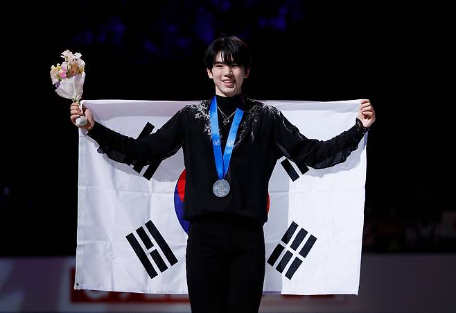 차준환이 25일 일본 사이타마의 수퍼 아레나에서 2023 ISU 세계 피겨스케이팅 선수권 남자 싱글 은메달을 목에 건 채 태극기를 손에 들고 환하게 웃고 있다. 한국 남자 선수 최초의 이 대회 메달이다./로이터 연합뉴스