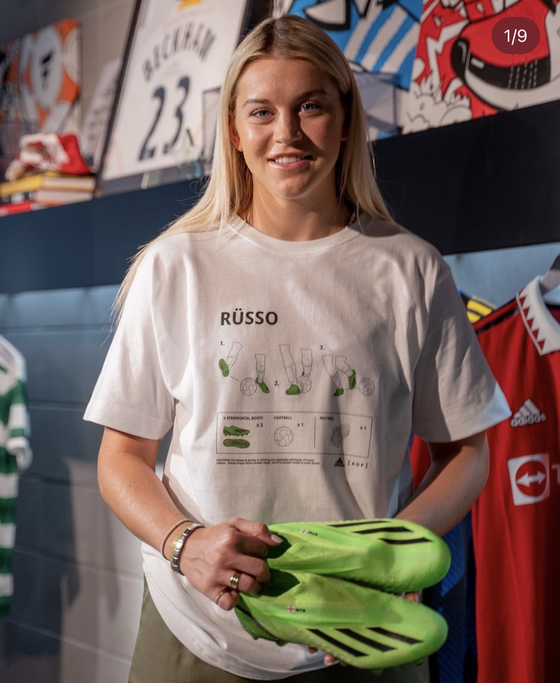 Manchester United striker Alessia Russo poses in a T-shirt commemorating her backheel goal at the 2022 Euros.  [ART OF FOOTBALL]