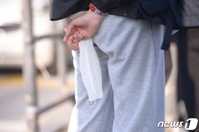 지하철·버스·택시 등 대중교통에 대한 마스크 착용 의무가 해제된 20일 오전 광주 서구 광천동 종합버스터미널 버스 정류장에서 한 시민이 손에 마스크를 들고 있다. 2023.3.20/뉴스1 ⓒ News1 이승현 기자