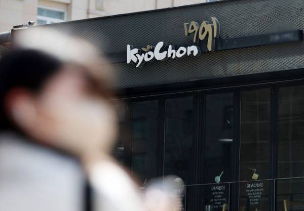 26일 서울 시내 한 교촌치킨 매장 옆을 시민이 지나가고 있다. 뉴시스