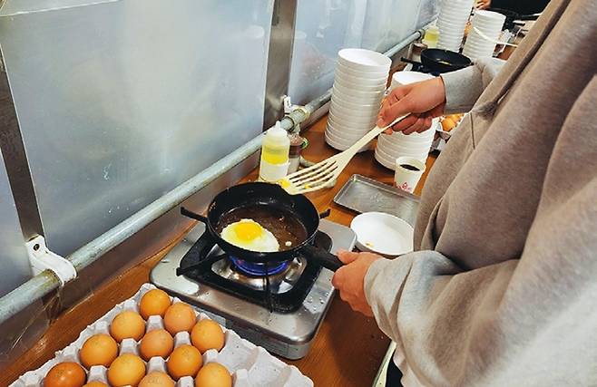 한 학생이 셀프코너에서 달걀프라이를 조리 중이다.