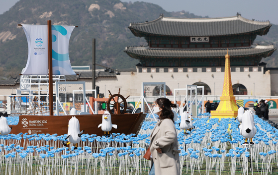 A passerby walks past an outdoor exhibition featuring Boogi the seagull, the Busan Expo 2030 mascot, at Gwanghwamun Square in central Seoul on Thursday. The Busan Expo bidding committee organized the promotional event, which will run from Thursday to April 3, to rally support for Busan’s bid to host the World Expo, ahead of an on-site visit by the inspection team from the Bureau International des Expositions.