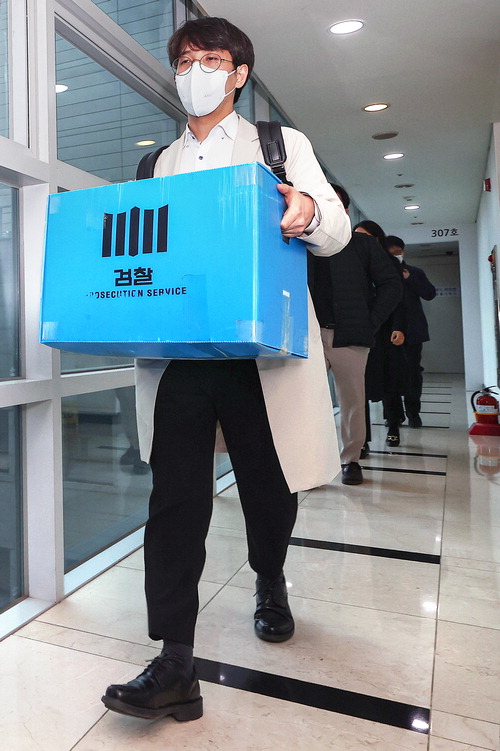30일 서울 서초구 양재식 변호사 사무실에서 압수수색을 마친 검찰 관계자들이 압수품을 옮기고 있다.  연합뉴스