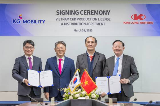 KG Mobility Chairman Kwak Jea-sun, second from left, and Nguyen Huu Luan, third from left, chairman of FUTA Group, pose after signing a licensing deal on March 30.[KG MOBILITY]