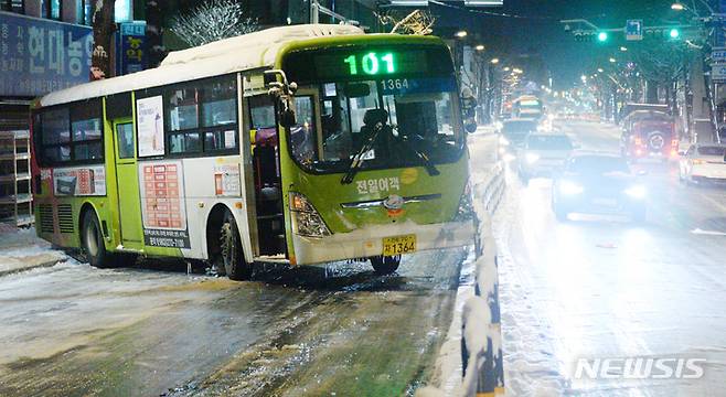 [전주=뉴시스] 김얼 기자 = 17일 전북 전주시 완산구 전동에서 한 시내버스가 빙판길에 미끌어져 차도을 막고 있다. 2022.12.17. pmkeul@newsis.com