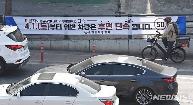[수원=뉴시스] 김종택 기자 = 차량의 후면 번호판을 찍어 교통 법규 위반 행위를 적발해 과태료를 부과하는 방식의 단속을 하루 앞둔 31일 경기도 수원시 한 거리에 후면 단속을 알리는 현수막이 내걸려 있다. 2023.03.31. jtk@newsis.com