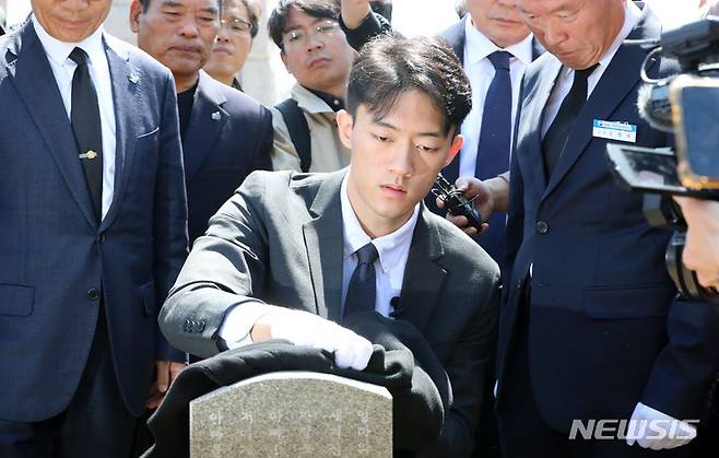 [광주=뉴시스] 김혜인 기자 = 고(故)  전두환씨의 손자인 전우원씨가 31일 오전 광주 북구 국립5 ·18민주묘지 내 김경철 열사의 묘소를 찾아 자신의 옷으로 묘비를 닦으며 넋을 위로하고 있다. 2023.03.31. hyein0342@newsis.com