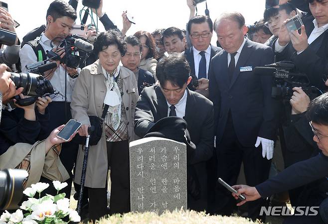 [광주=뉴시스] 김혜인 기자 = 고(故)  전두환씨의 손자인 전우원씨가 31일 오전 광주 북구 국립5 ·18민주묘지 내 문재학 열사의 묘소를 찾아 자신의 옷으로 묘비를 닦으며 넋을 위로하고 있다. 2023.03.31. hyein0342@newsis.com