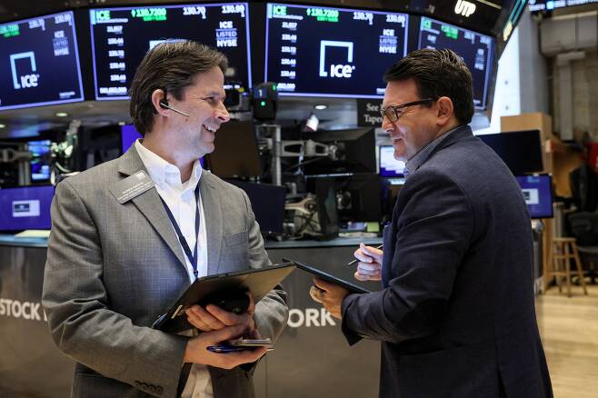 미국 뉴욕증권거래소(NYSE) 입회장에서 트레이더들이 웃으면서 대화하고 있다./AP 연합뉴스