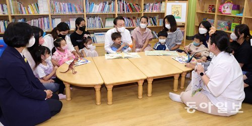 지난해 여름 윤석열 대통령이 한 어린이집을 찾아 아이들과 함께  어린이집 교사들의 이야기를 듣고 있는 모습. 동아일보DB