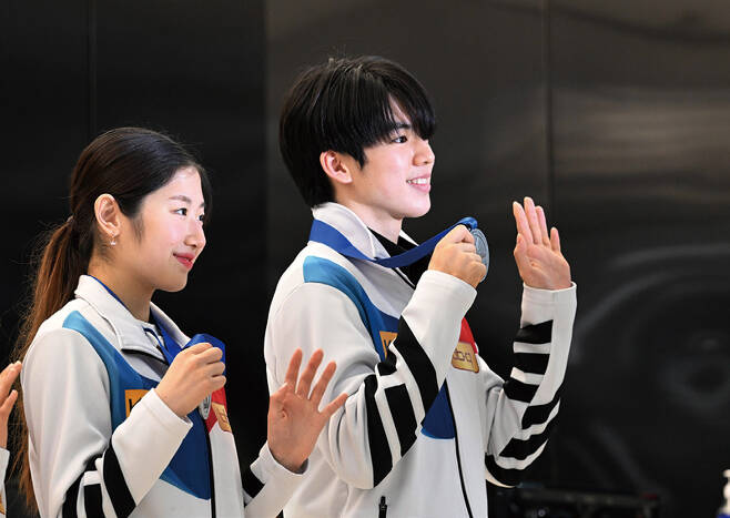 2023 피겨스케이팅 세계선수권대회에서 나란히 은메달을 획득한 이해인·차준환이 3월27일 김포국제공항을 통해 귀국하며 메달을 들어 보이고 있다. ⓒ연합뉴스