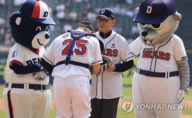 김인식 전 감독에게 예를 표하는 양의지 (서울=연합뉴스) 김도훈 기자 = 1일 서울 잠실야구장에서 열린 2023 프로야구 개막전 롯데 자이언츠와 두산 베어스의 경기에서 양의지가 시구를 마친 김인식 전 두산 감독에게 예를 표하고 있다. 2023.4.1 superdoo82@yna.co.kr