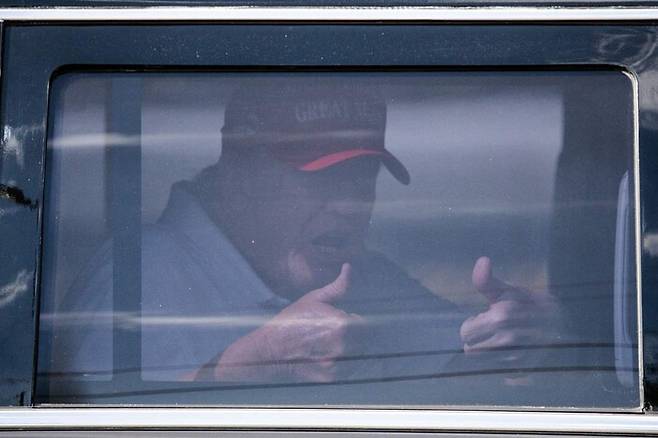 도널드 트럼프 전 미국 대통령이 1일 플로리다주 팜비치의 트럼프내셔널골프장을 떠나며 차창 밖을 향해 엄지손가락을 치켜들고 있다. 팜비치/AFP 연합뉴스