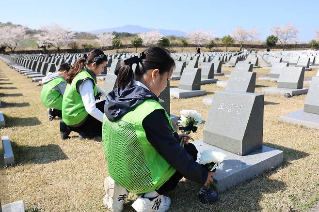 제75주년 제주4·3추념일을 하루 앞둔 2일 제주시 봉개동 제주4·3평화공원에서 어린이들이 묘비에 국화를 놓으며 희생자들의 넋을 기리고 있다. 연합뉴스