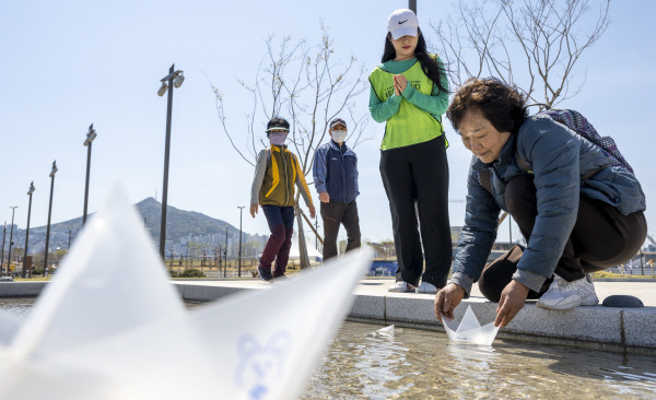 3일 부산항 북항 재개발 1단계 구역에서 시민이 소원을 적은 모형 배를 물에 띄우고 있다. 김영훈 기자