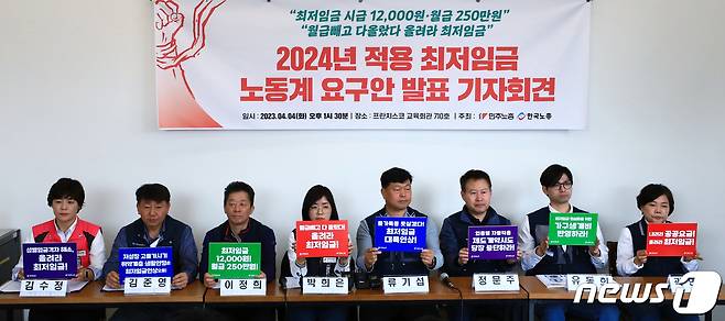 4일 오후 서울 중구 프란치스코 교육회관에서 열린 2024년 적용 최저임금 노동계 요구안 발표 기자회견에서 김수정 학비노조 부위원장(왼쪽부터)과 김준영 금속노련 사무처장, 이정희 민주노총 정책실장, 박희은 민주노총 부위원장, 류기섭 한국노총 사무총장, 정문주 한국노총 사무처장, 유동희 한국노총 선임정책차장, 곽현희 콜센터 본부장이 손팻말을 들어 보이고 있다. 2023.4.4/뉴스1 ⓒ News1 박정호 기자