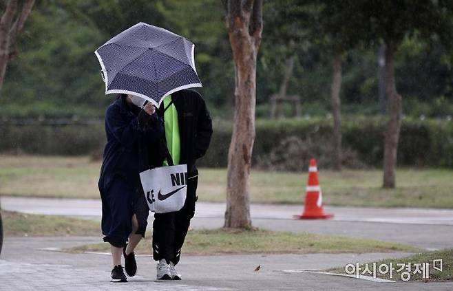 10일 서울 반포한강공원에서 시민들이 갑자기 불어온 비바람에 우산을 움켜쥔 채 걷고 있다./김현민 기자 kimhyun81@