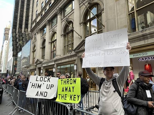 3일(현지시간) 도널드 트럼프 미국 전 대통령이 기소절차를 하루 앞두고 도착한 뉴욕 맨해튼 트럼프타워 주변에  트럼프 지지자들과 반대하는 시민들이 나란히 서서 구호를 손에 들고 있다. 뉴욕/김유진특파원