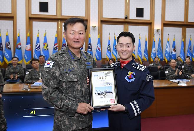 정상화(왼쪽) 공군참모총장이 ‘2022년 공군 최우수 조종사’에 선정된 원중식 소령에게 대통령 표창을 수여한 뒤 기념사진을 찍고 있다. <사진제공=공군>