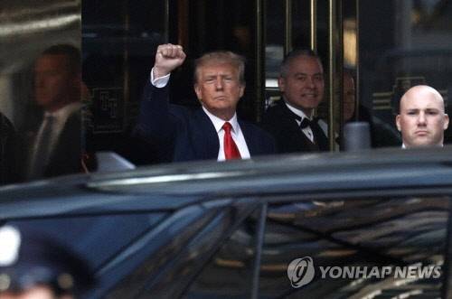 도널드 트럼프 전 대통령이 숙소인 트럼프 타워에서 나온 뒤 주먹을 들어 지지자들에게 인사하고 있다. 뉴욕 EPA=연합뉴스