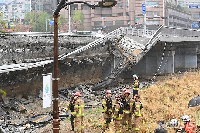 [성남=뉴시스] 김종택 기자 = 5일 오전 경기도 성남시 분당구 정자교 난간이 무너지는 사고가 발생해 소방 대원 등 관계자들이 현장을 수습하고 있다. 이 사고로 교각 가드레일과 이정표 등이 산책로로 쏟아져 30대 여성 1명이 숨지고 30대 남성 1명은 중상을 입어 병원에서 치료 중이다. 2023.04.05. jtk@newsis.com