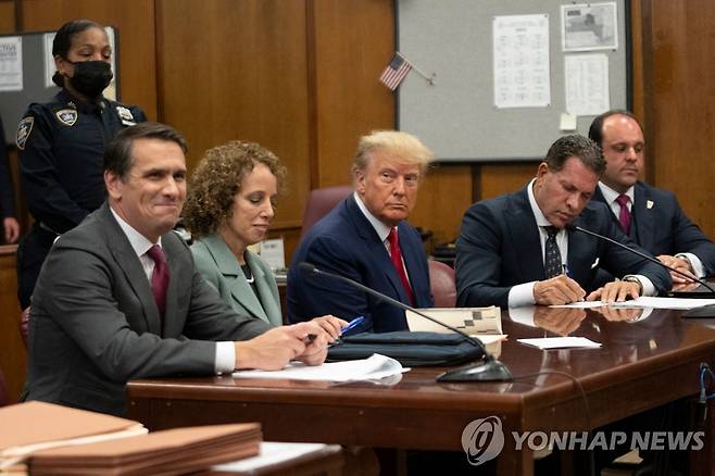 기소인부절차 밟는 트럼프 전 美 대통령 (뉴욕 AFP=연합뉴스) 도널드 트럼프 전 미국 대통령(가운데)이 4일(현지시간) 뉴욕 맨해튼 형사법원에서 기소인부절차를 밟고 있다. 이날 트럼프 전 대통령은 검찰 기소에 대해 혐의를 부인한 것 외에는 별다른 발언을 하지 않았다. 지난달 30일 맨해튼 대배심은 2016년 대선을 앞두고 성인 배우와의 성추문 의혹을 덮기 위해 입막음용 돈을 건넨 혐의로 트럼프 전 대통령을 기소했다. 2023.04.05 ddy04002@yna.co.kr