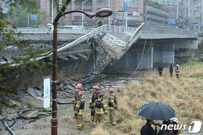 5일 오전 경기 성남시 분당구 정자동 정자교 보행로 일부 구간과 난간이 붕괴되는 사고가 발생, 출동한 소방 구조 대원 등이 분주히 움직이고 있다. 이 사고로 30대 여성 A씨가 숨지고 30대 남성 B씨는 중상을 입어 병원에서 치료 중이다. 2023.4.5/뉴스1 ⓒ News1 김진환 기자