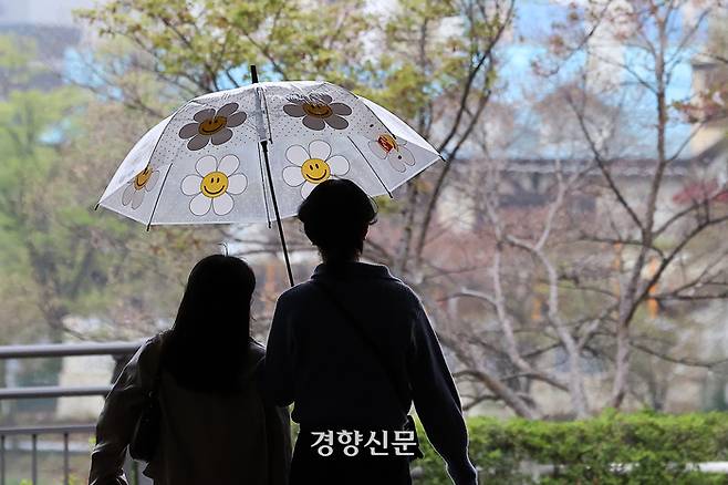 산발적인 봄비가 이어진 6일 서울 송파나루 공원을 찾은 시민들이 꽃이 그려진 우산을 쓴 채 걷고 있다. 조태형 기자