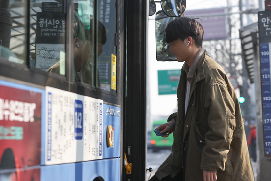 A person gets on a bus without a mask on March 20, the first day the public transportation mask mandate was lifted. [YONHAP]