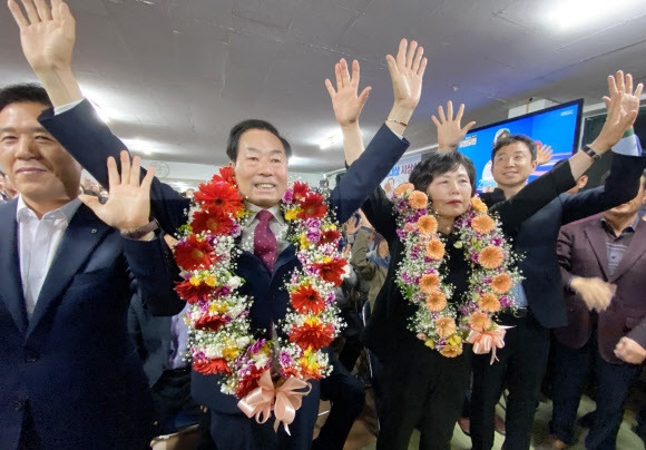 성낙인 경남 창녕군수 무소속 후보가 6일 오전 1시쯤 창녕군수선거 당선이 확정된 뒤 부인과 함께 선거사무실에서 꽃다발을 목에 걸고 인사를 하고 있다. 2023.4.6. 연합뉴스