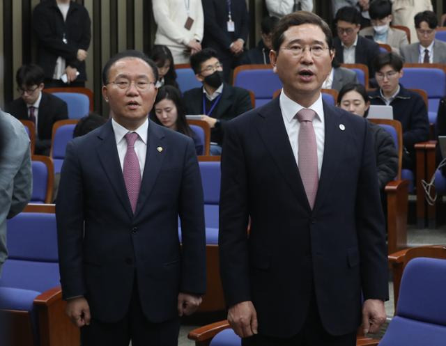 국민의힘 원내대표 후보 윤재옥(왼쪽부터), 김학용 의원이 7일 서울 여의도 국회에서 열린 2023 원내대표 선출 의원총회에서 애국가를 부르고 있다. 뉴스1