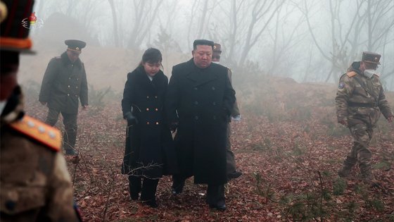 김정은 국무위원장이 지난달 19일 평북 철산군 동창리에서 발사한 미사일 참관지로 가기 위해 딸의 손을 잡고 걷고 있다. [뉴시스]