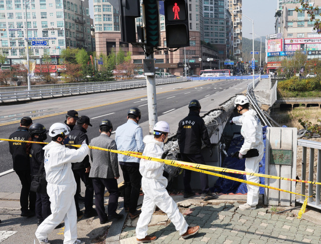 보행로가 무너지며 두 명의 사상자가 발생한 경기도 성남시 정자교에서 7일 오전 경찰과 국과수 등 관계자들이 사고 원인을 찾기 위한 합동 감식을 하고 있다. 연합뉴스