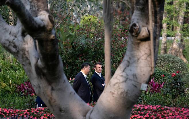 에마뉘엘 마크롱(왼쪽) 프랑스 대통령과 시진핑 중국 주석이 7일 광둥성 광저우의 광둥성장 관사 정원을 산책하고 있다./로이터 연합뉴스